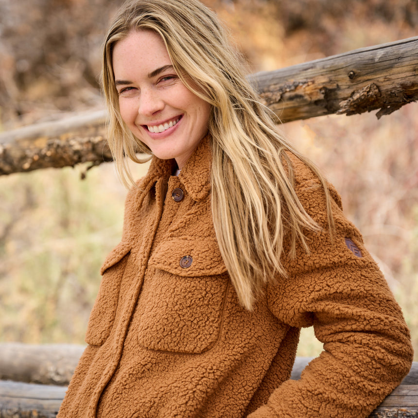 Woman wearing a brown coat in a natural setting